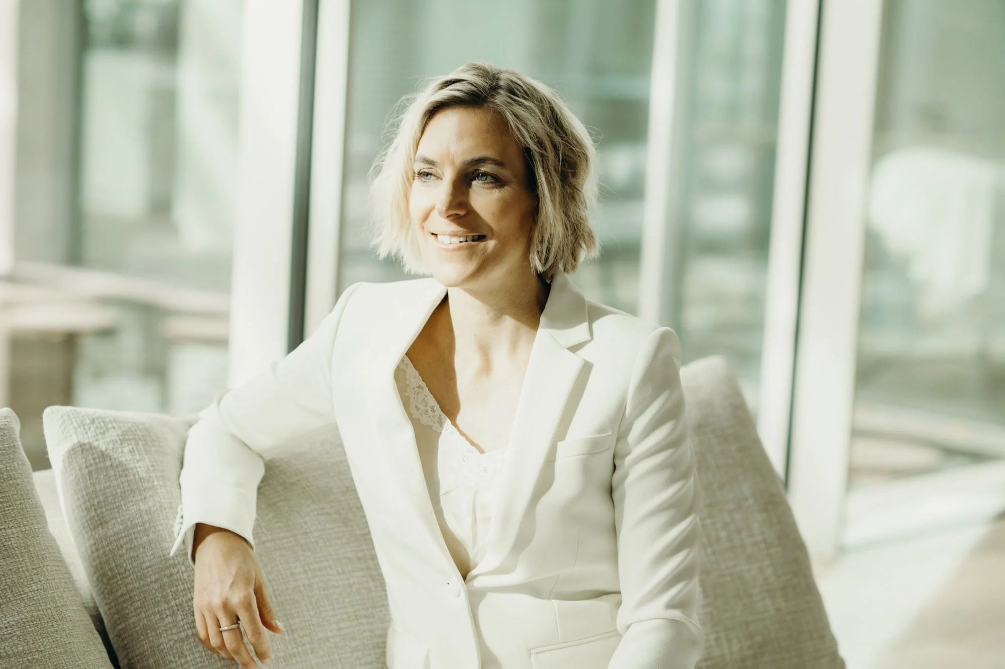 Weibliche Führungskraft in einer entspannten Büroumgebung, wirkt souverän und natürlich.