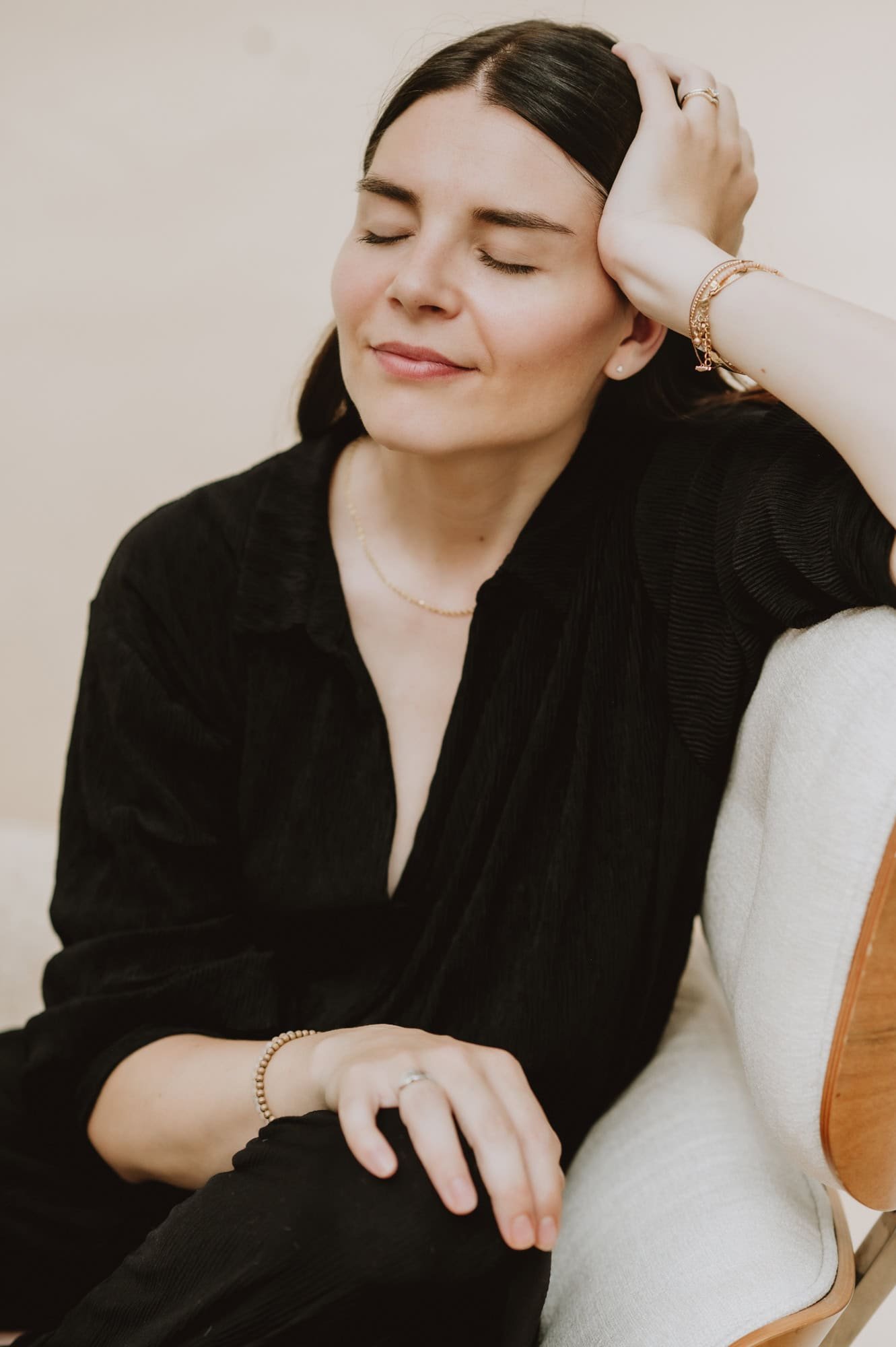 Content Creatorin sitzt mit geschlossenen Augen auf einem Stuhl während einem Bradnd Fotoshoot.