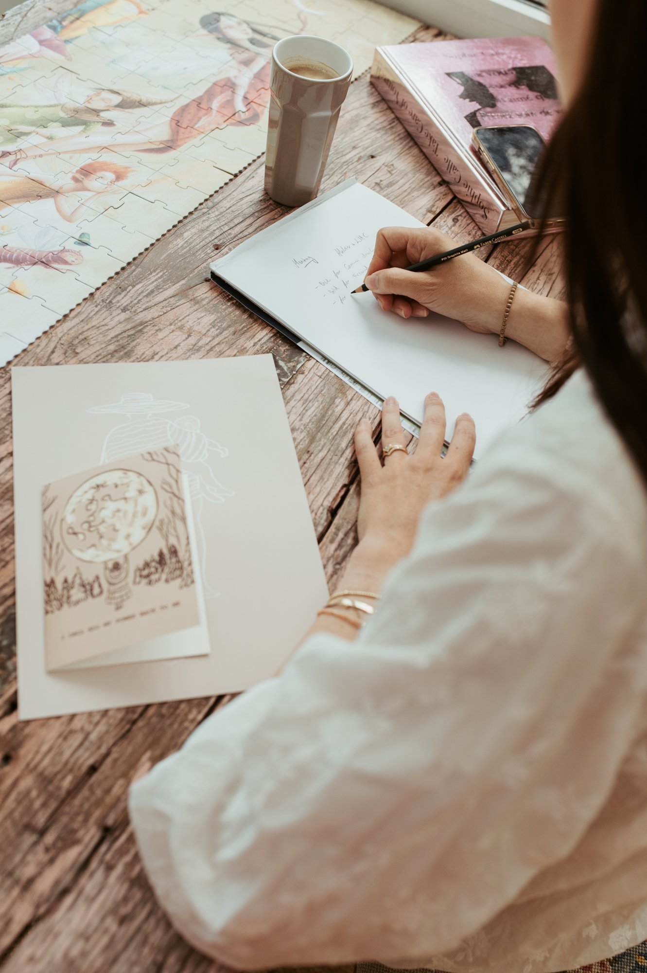 Künstlerin zeichnet an einem Holztisch