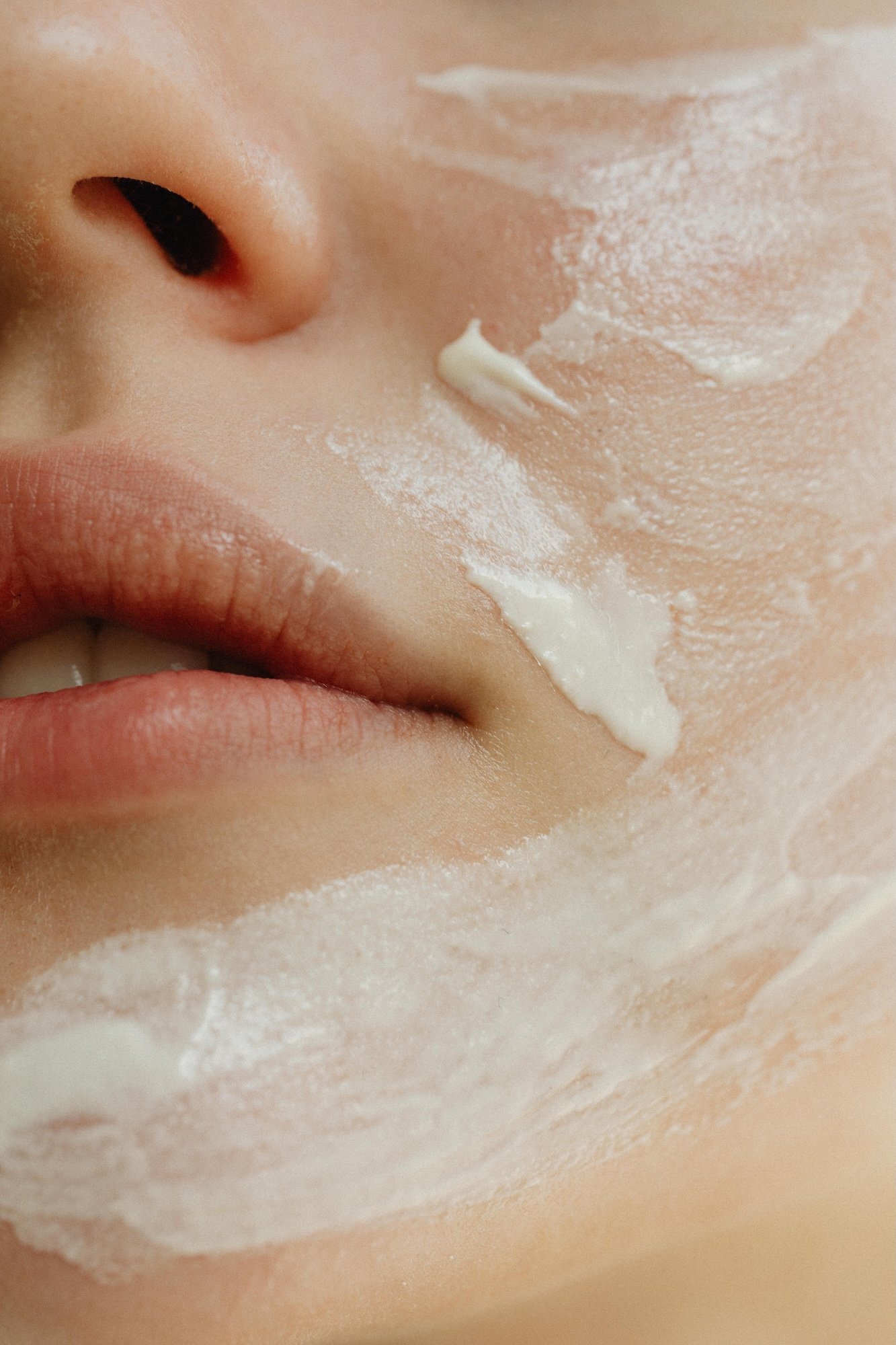 Lähikuva kasvoista, jossa levitetään kasvovoidetta kasvohoidossa Tampereella.