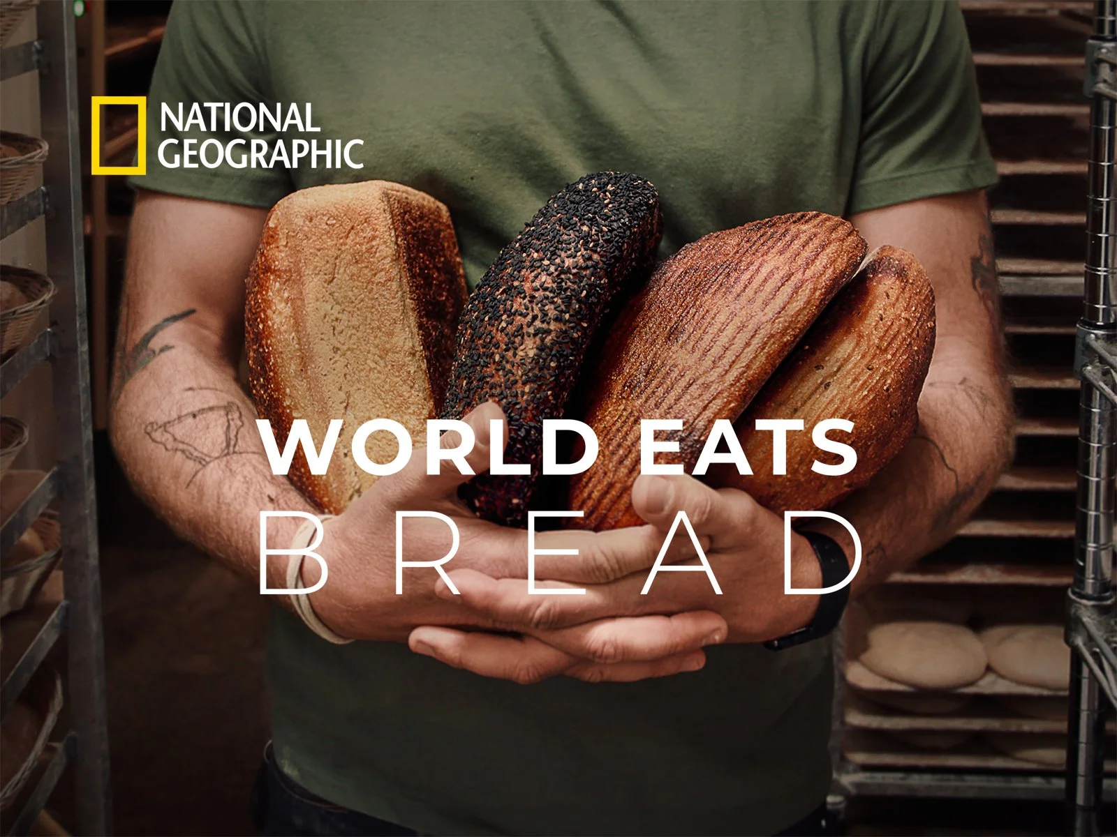A man wearing a green t-shirt holding loaves of bread in his arm. World Eats Bread text across the center. National Geographic logo in the upper left corner.