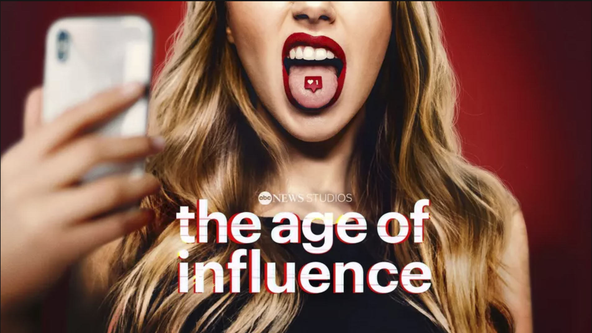 A young blonde woman with red lipstick takes a selfie with her tongue sticking out. A heart icon on her tongue.