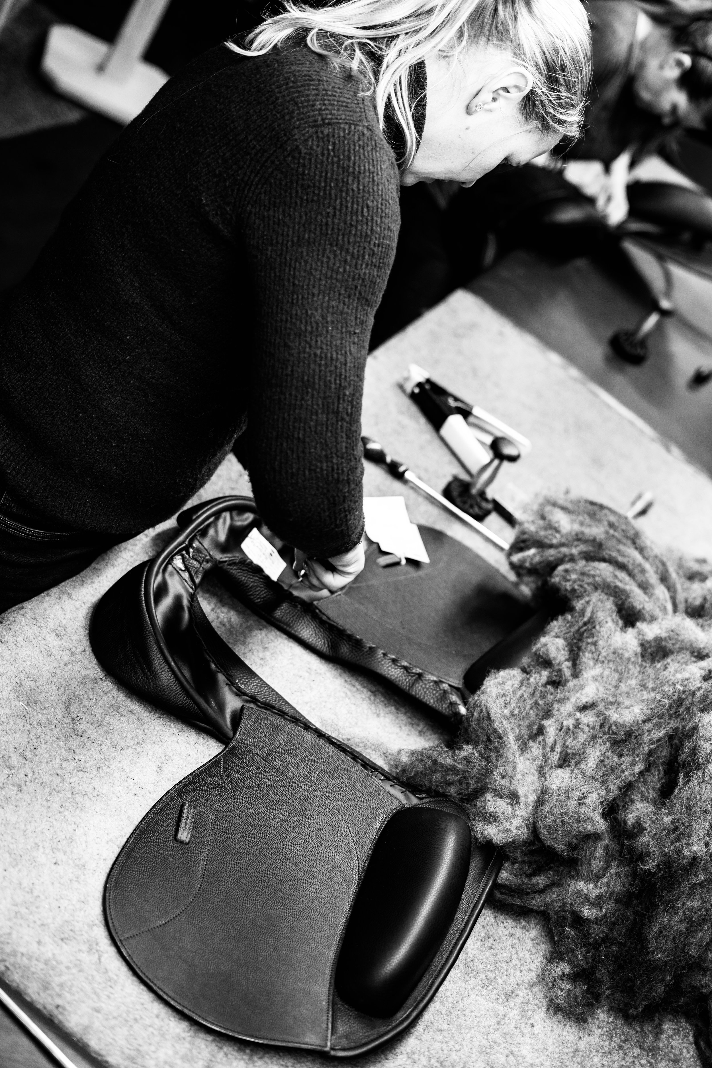 Flocking a Custom Saddlery saddle with wool. Panels of the saddle can be flocked to conform to the horse's shape.  Custom Saddlery fitter.