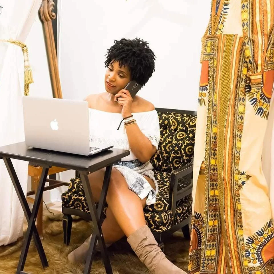 Goddessa using her phone and laptop while communicating with clients