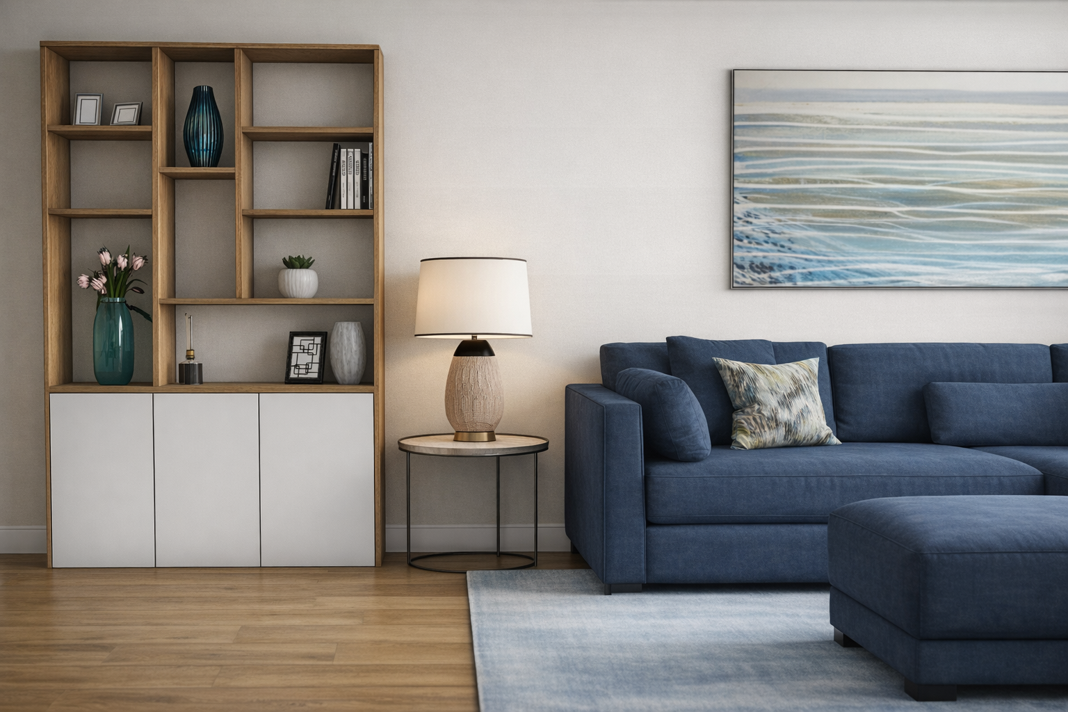 Living room with blue sofa, patterned pillow, side table with lamp, wooden bookshelf, artwork, and light wood flooring.