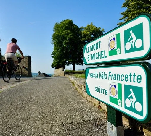 Des panneaux routiers indiquent la direction vers le Mont Saint Michel et la VéloFrancette pour le vélo.