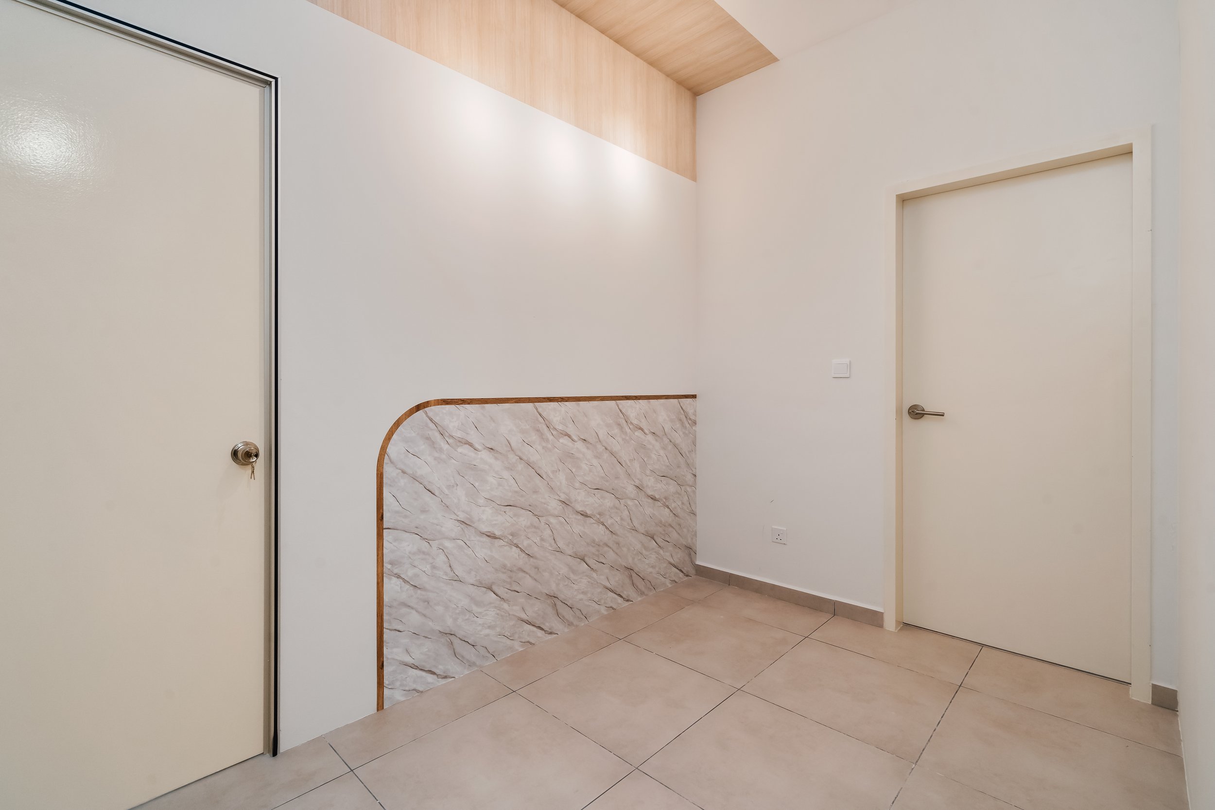 Interior view of a minimalistic room with white walls, a watermarked marble pattern partition, beige tiled floor, and white doors with metallic handles.