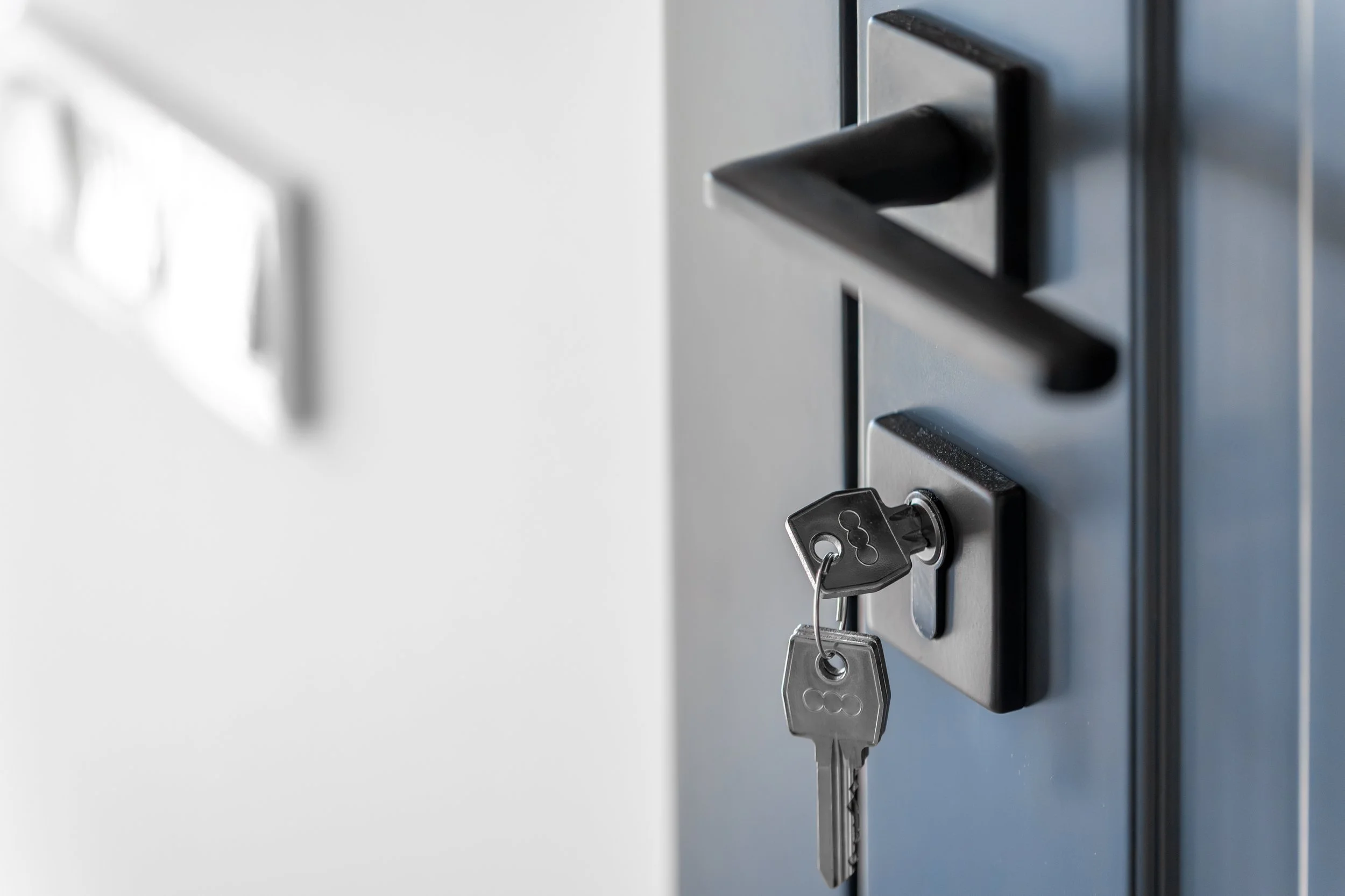 Close-up of a keypad lock with a key inserted, mounted on a metal door or panel.