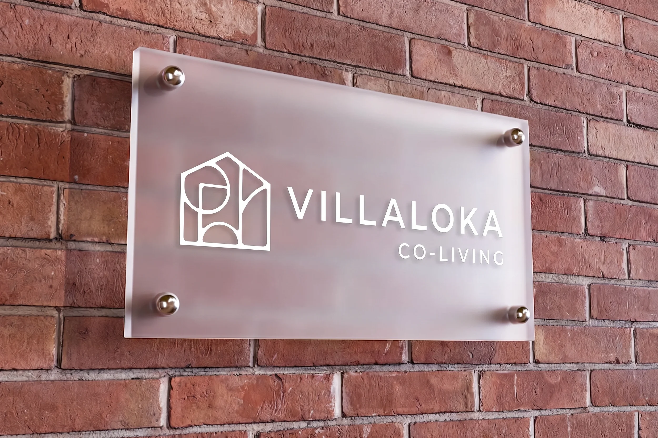 Sign for Villako Co-Living mounted on a brick wall.