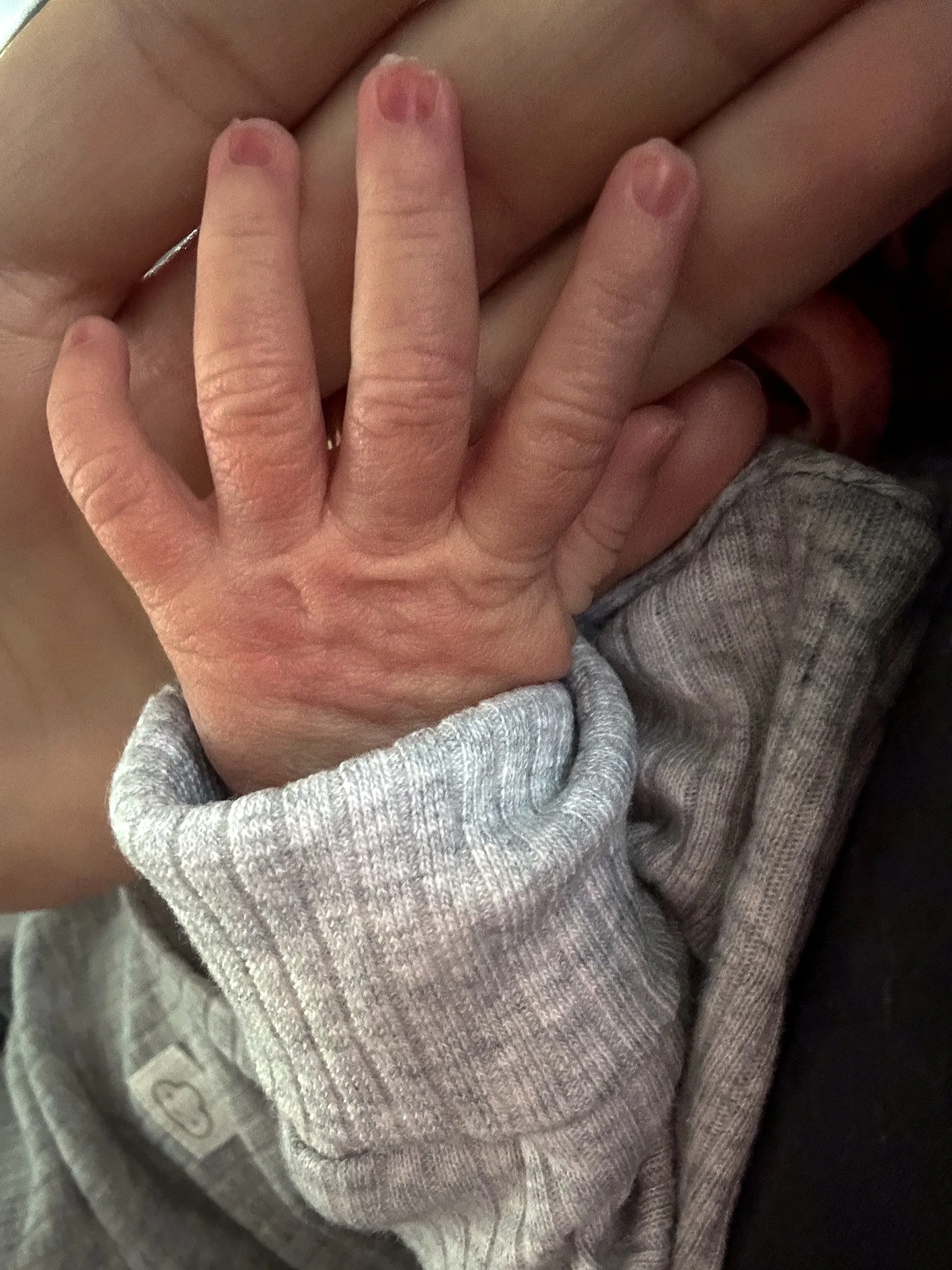 Hände eines Erwachsenen und eines Kindes, die sich berühren, wobei die Hand des Kindes auf der Hand des Erwachsenen liegt.