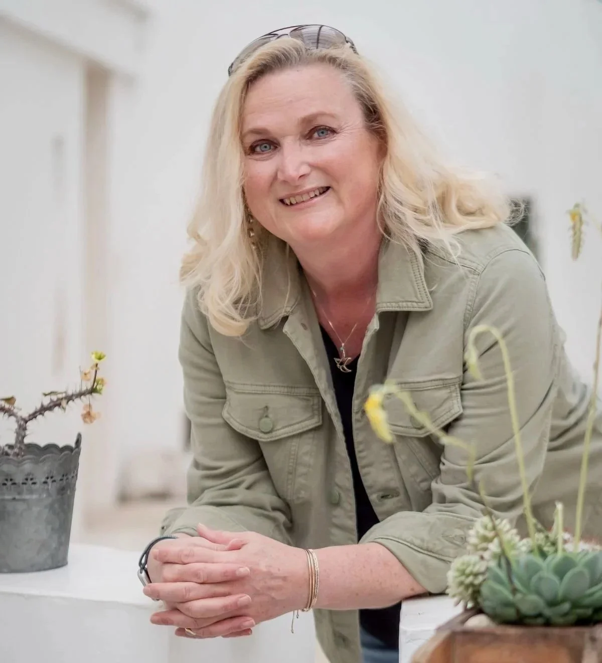 Claudia Meisinger die an einem weißen Tisch mit Pflanzen steht.