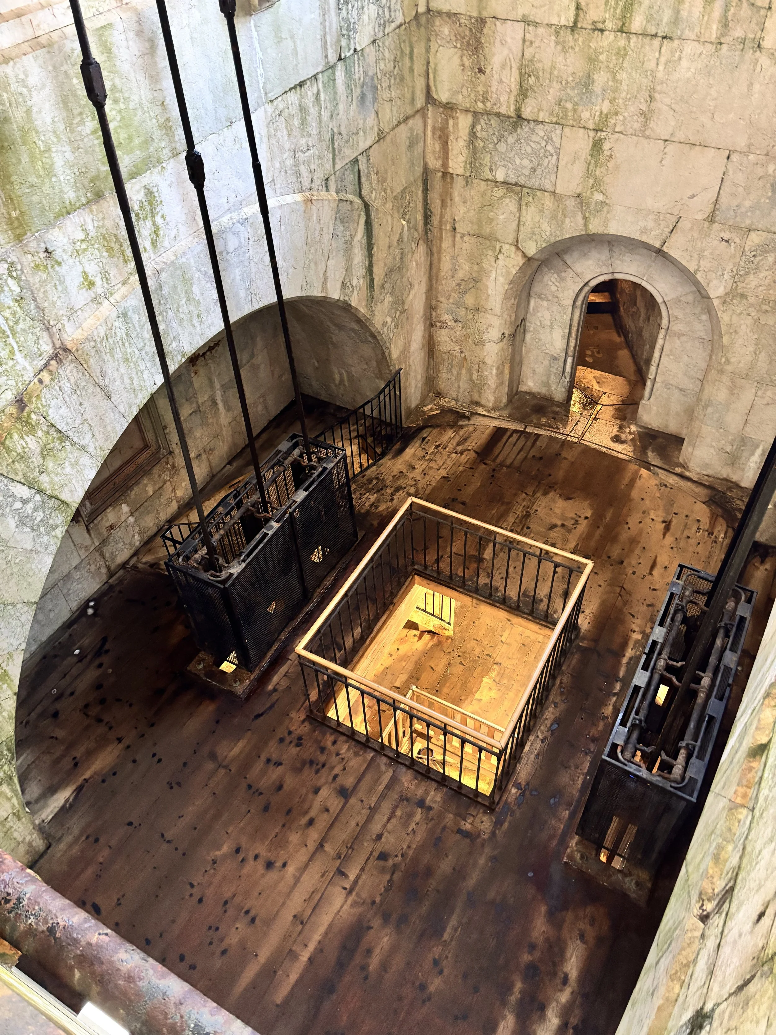 Achterbahn im Inneren eines alten Gebäude, mit Holzparkettboden, Steingemauer und Aufzügen für die Bahn.