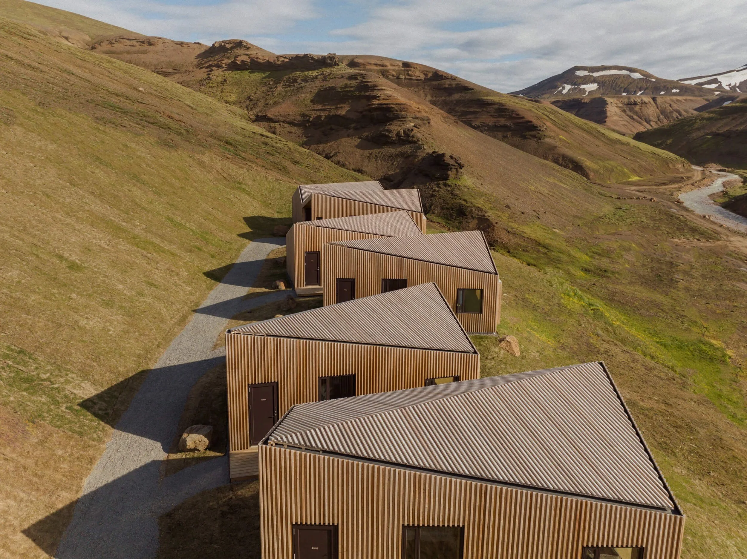 Modern nordic lodges nestled in the Icelandic Highlands, with views of the mountain range from all directions.