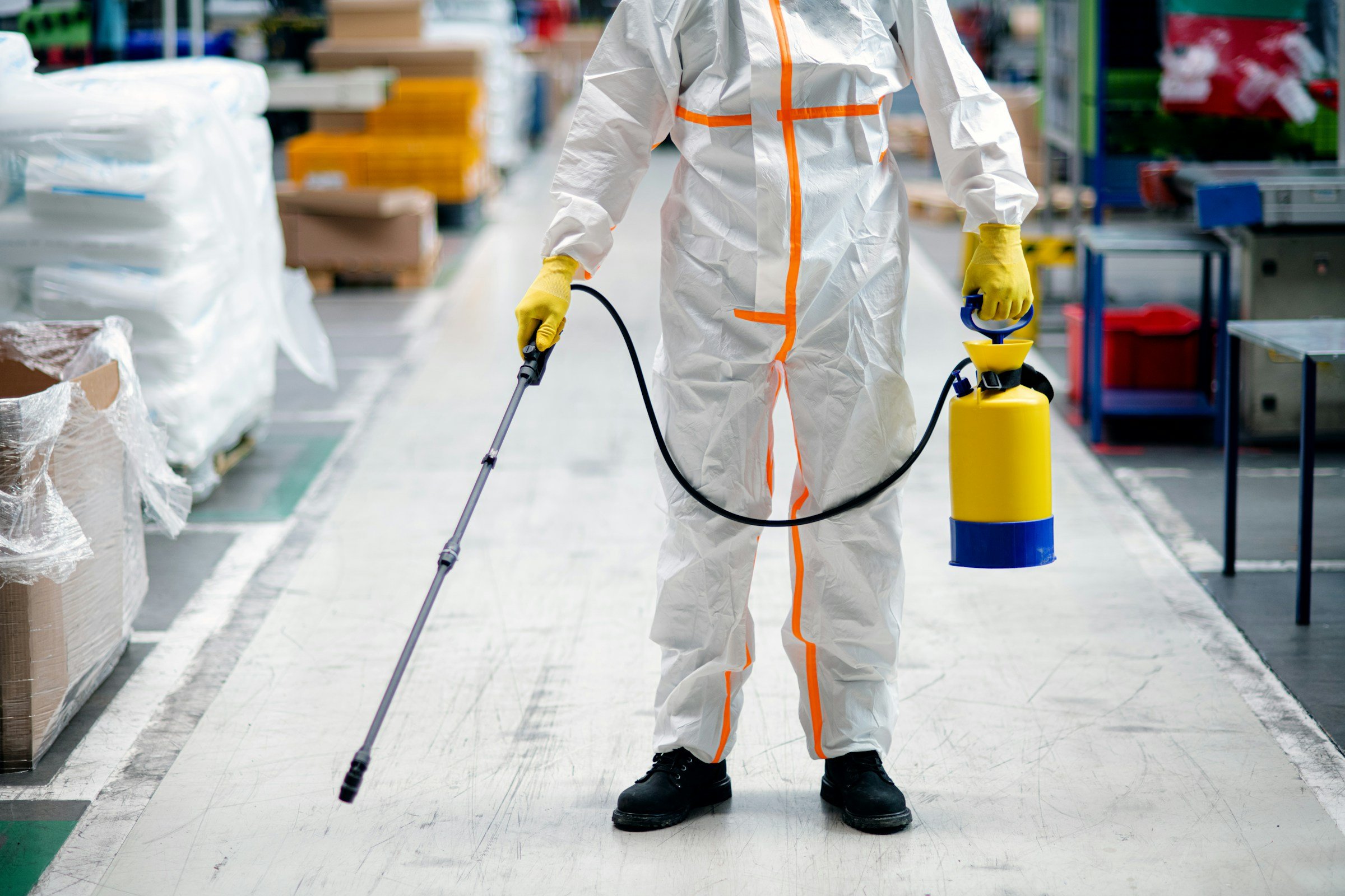 Man working with hazardous substances wearing hazmat suit in factory