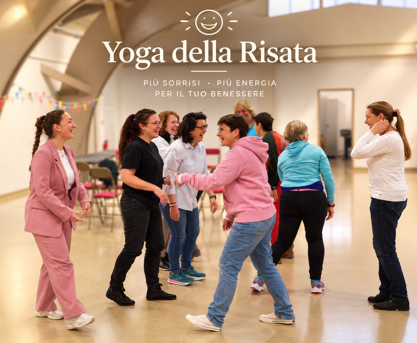 Un gruppo di persone che praticano yoga della risata in una sala, sorridendo e interagendo tra loro.