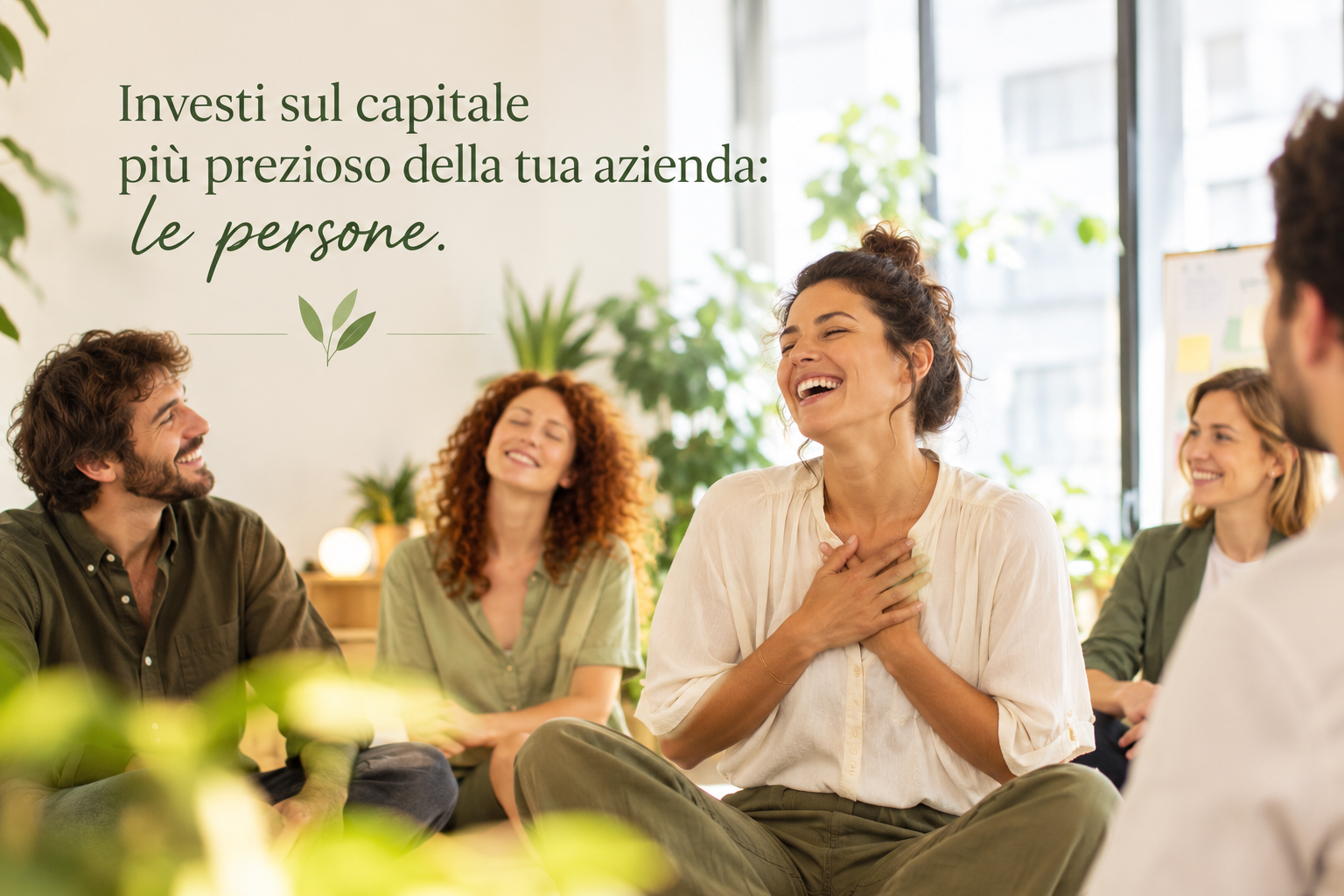 Un gruppo di persone che ridono e sorridono in un'opportunità di team building o riunione in ufficio, con decorazioni e piante sullo sfondo.