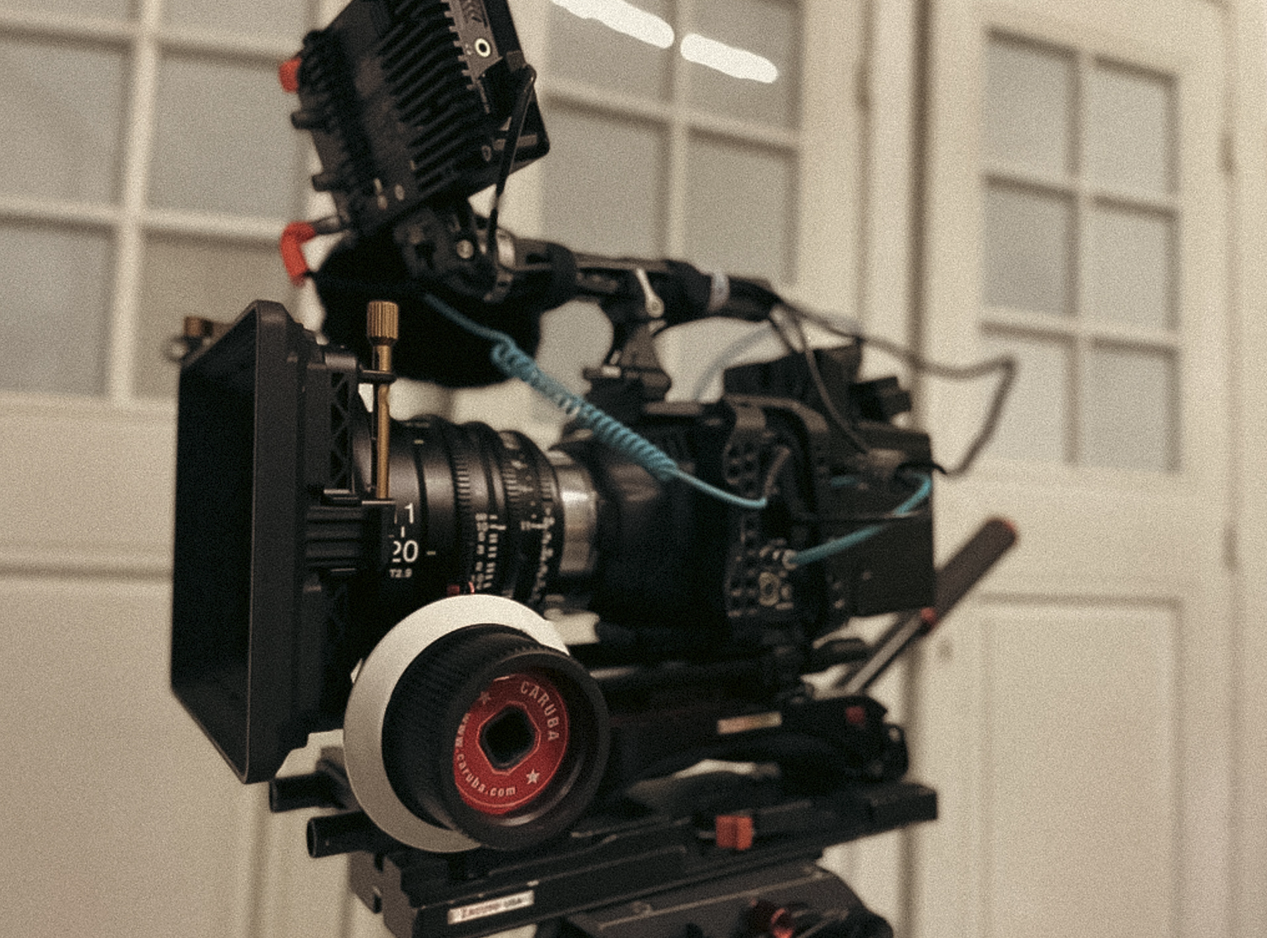 Professionele filmcamera op statief in een kamer met witte paneelwanden