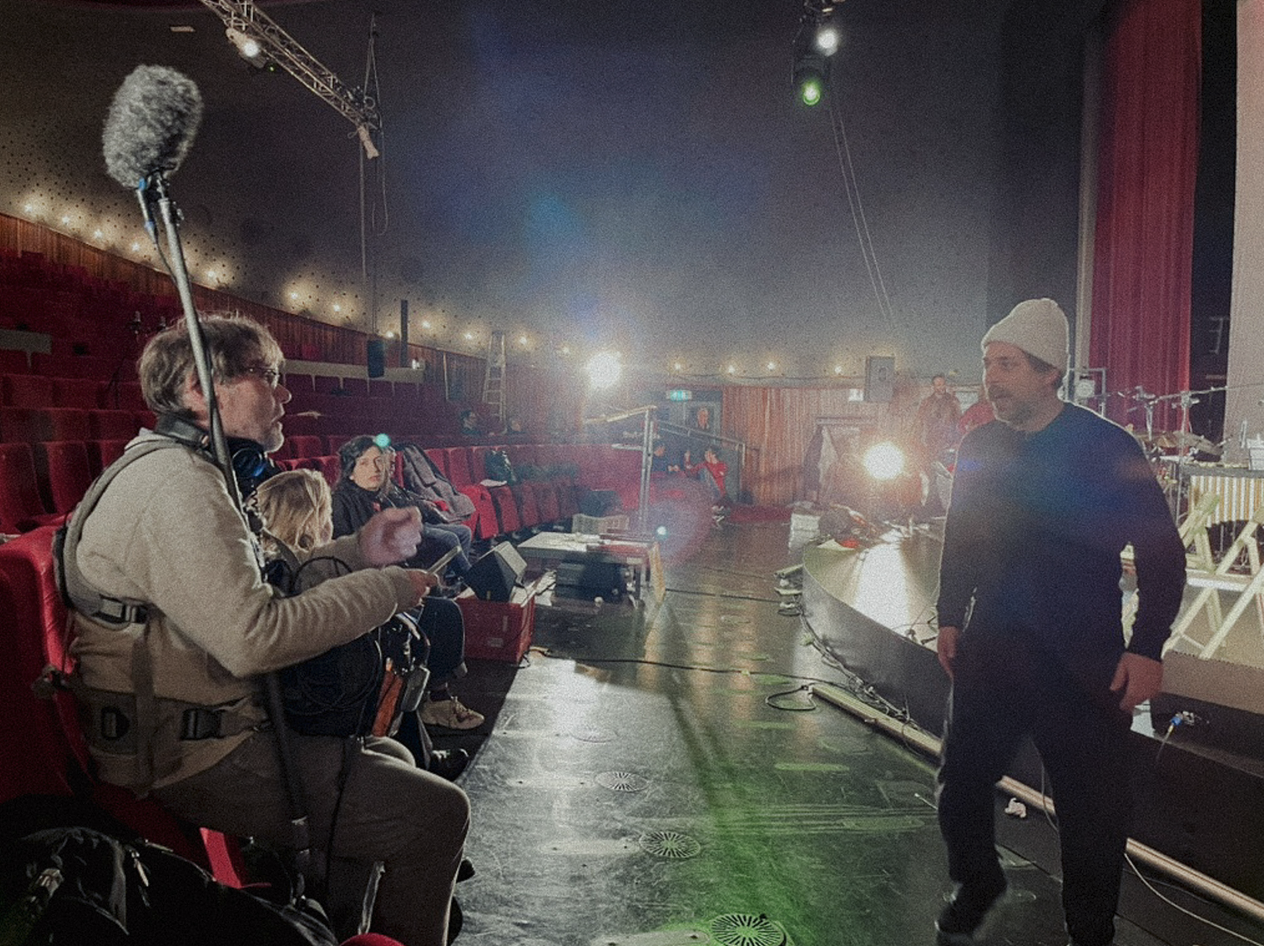 Opname in een theater met mensen en technische apparatuur.