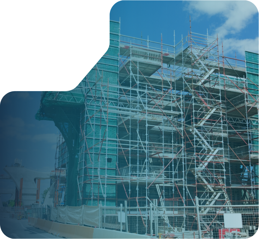 A building covered in construction scaffolding with blue-tinted safety netting.