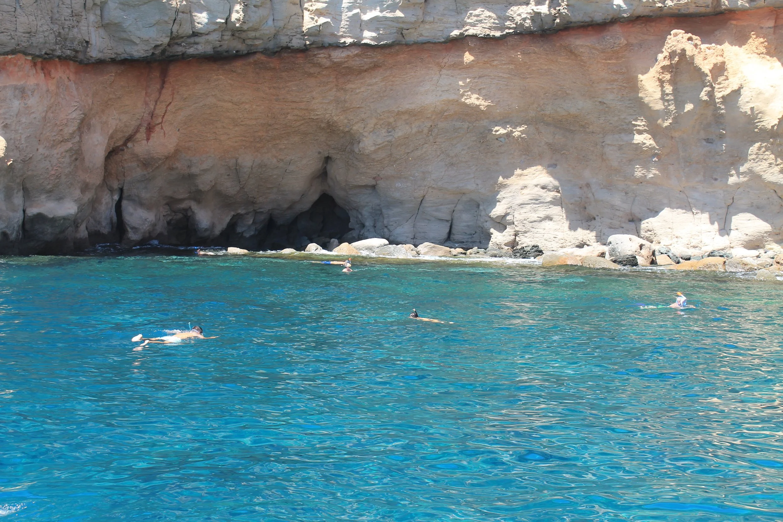 People snorkelling in clear blue waters.
