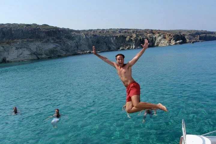 Person jumping into the water from a catamaran.
