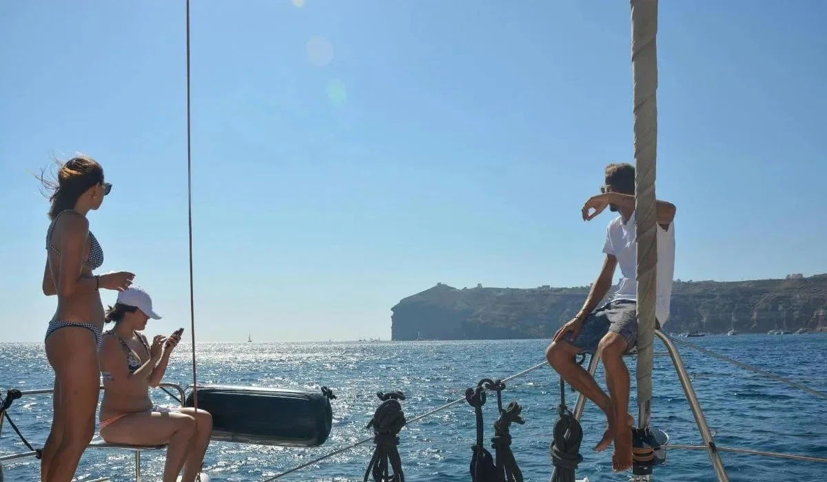 Four people on a catamaran on a sunny day.