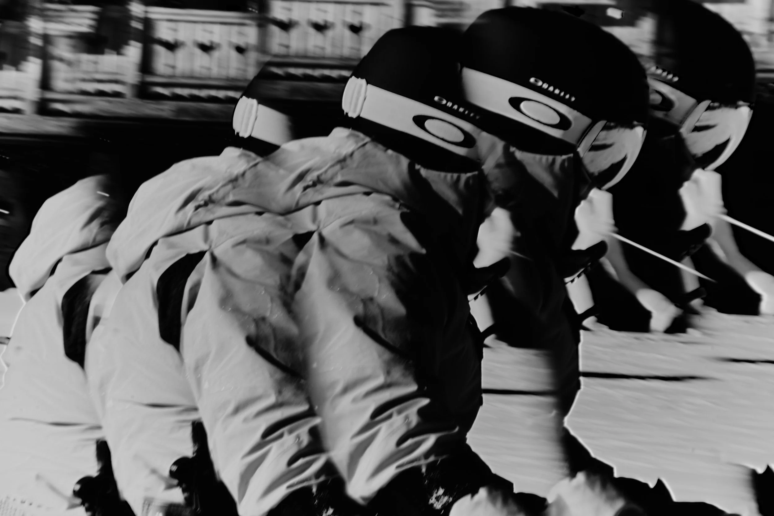 A black and white motion blurred image of an adaptive skier.