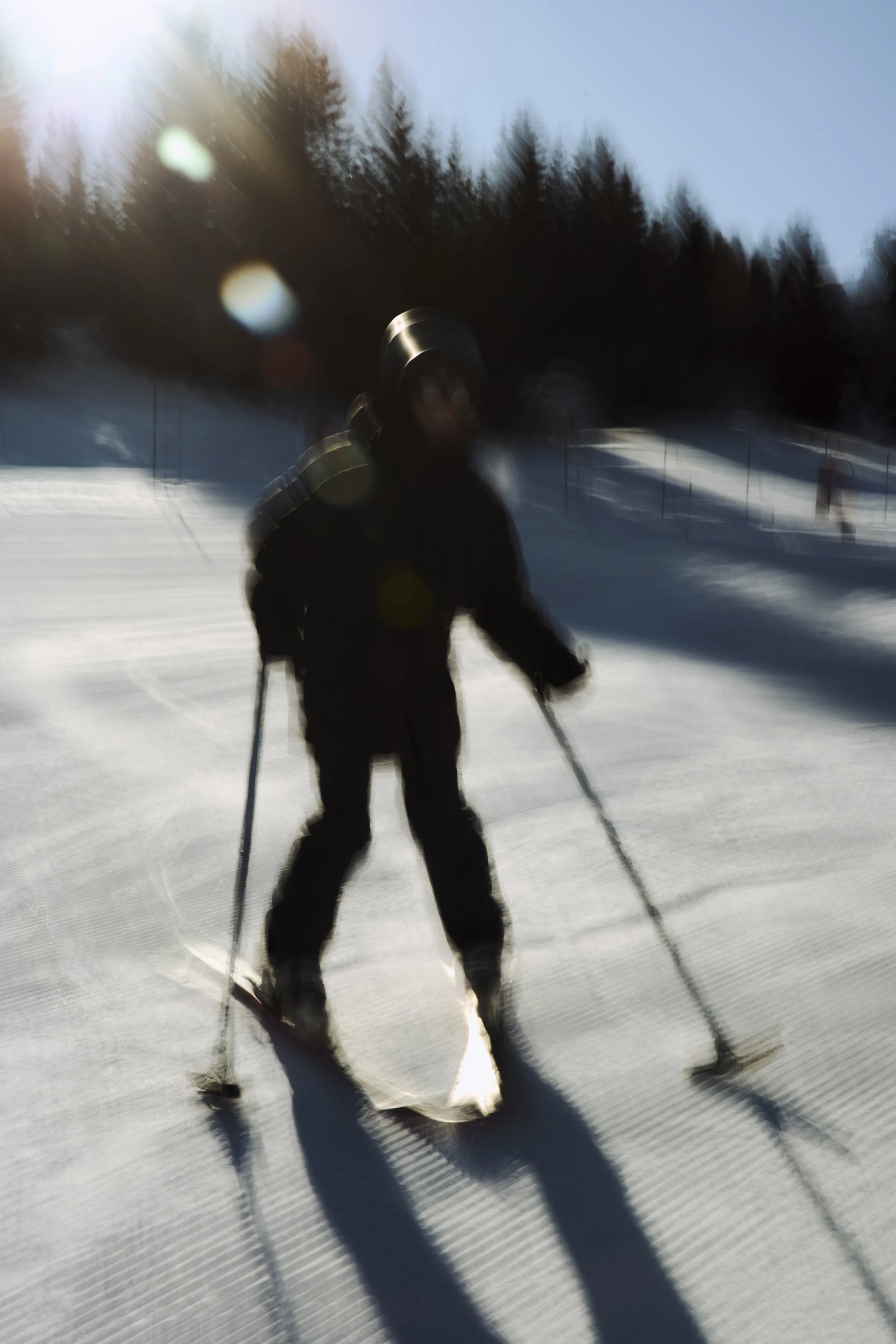 Out on the slopes with trees in the background under a bright blue sky.