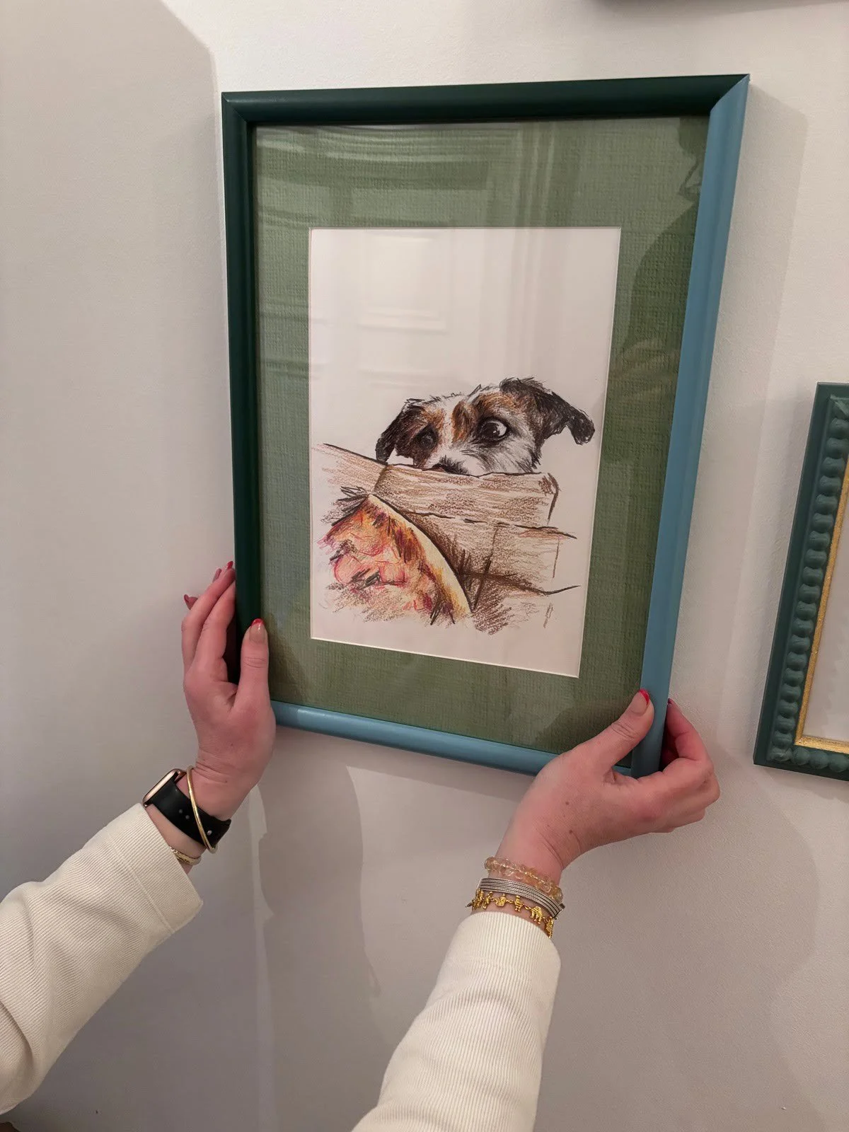 Customer hanging a hand drawn pet portrait gift
