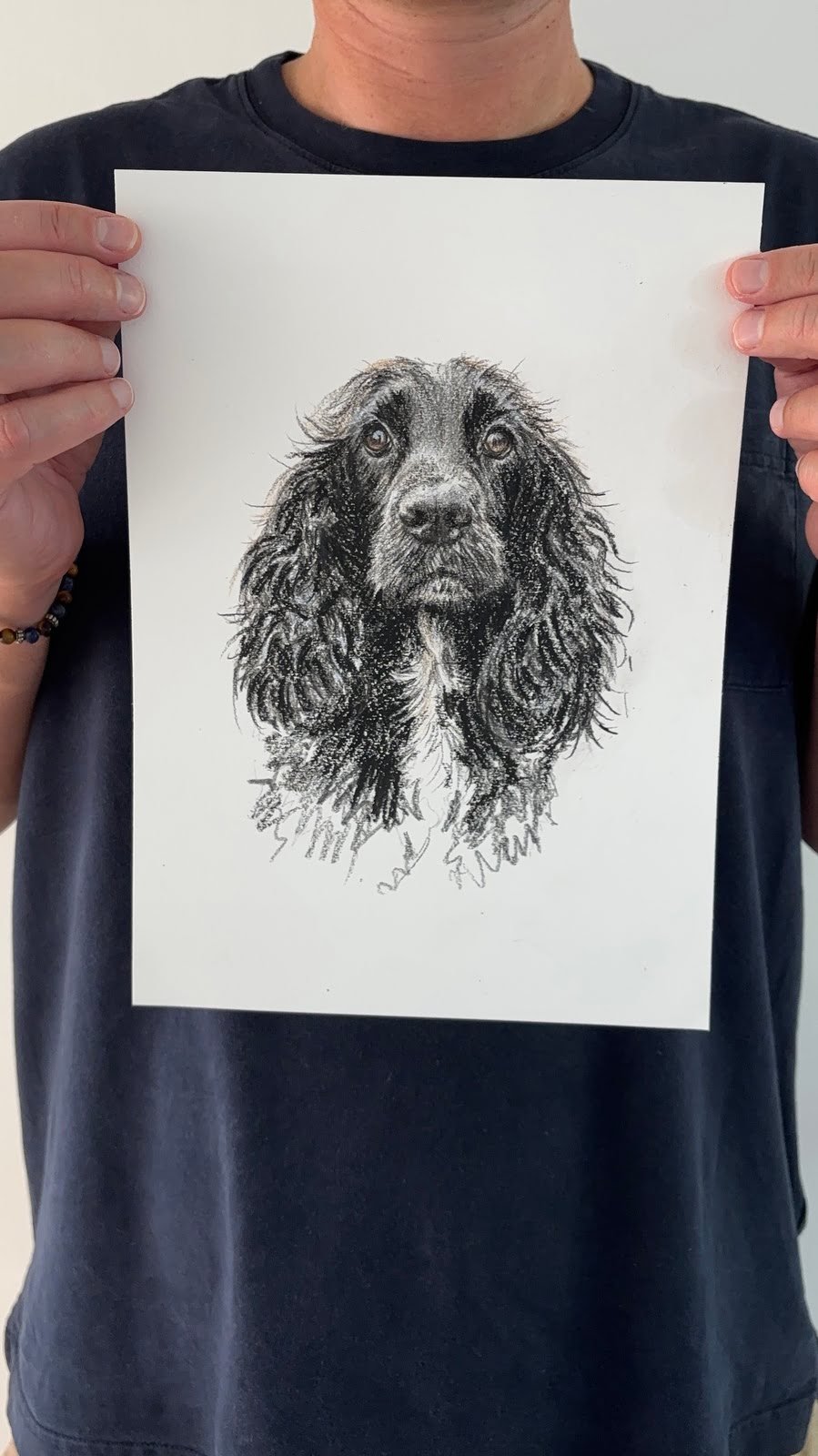 Artist holding up custom pet portrait of cocker spaniel