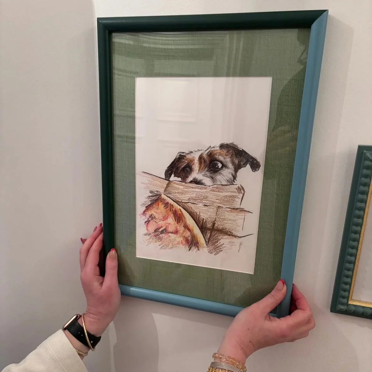 Customer hanging a hand drawn pet portrait