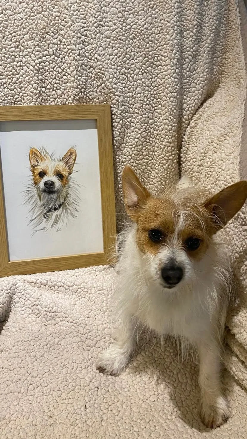 Pebbles next to her custom pet portrait