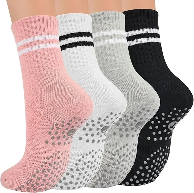 Four pairs of athletic crew socks in pink, white, gray, and black, each with two white stripes near the top and dotted grips on the soles.