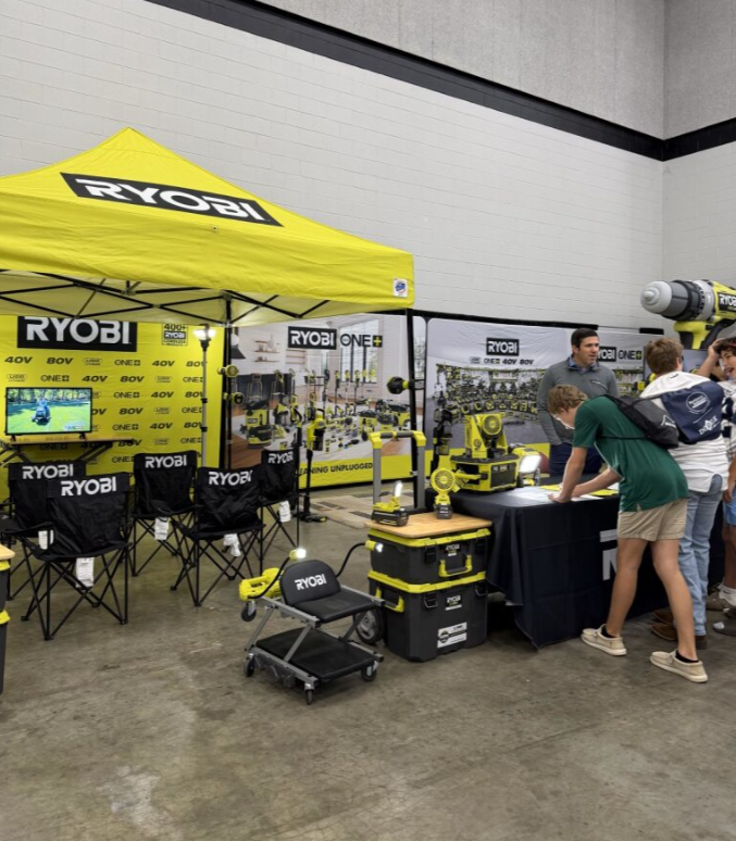 Ryobi booth at a trade show with power tools, chairs, and a small display area