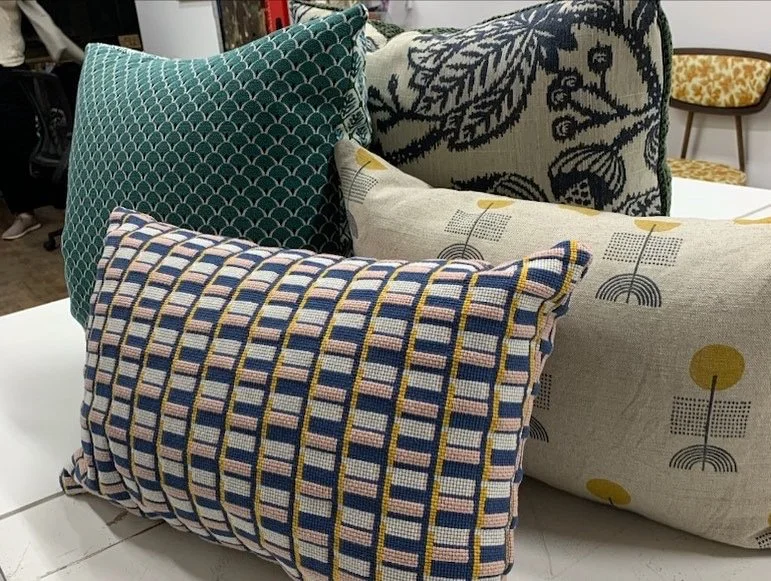 A collection of decorative throw pillows with various patterns on a white surface.