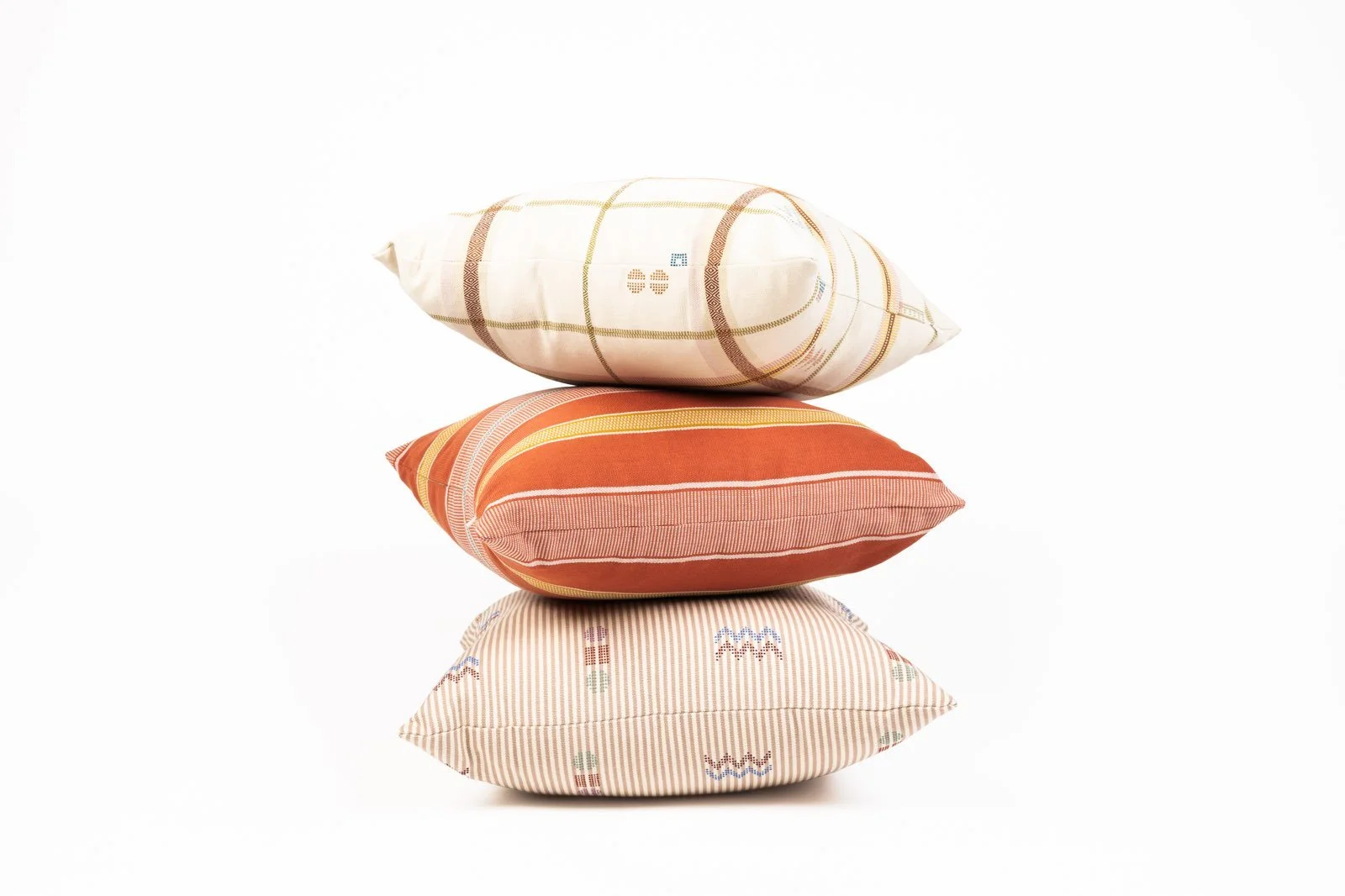 Multicolor orange, yellow and gold striped pillows stacked