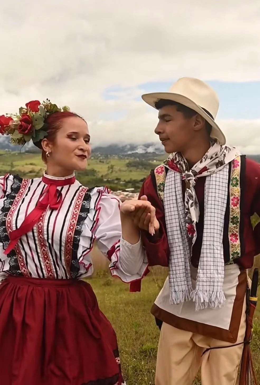 Traditional Latin American dancers in cultural dress performing in mountain landscape