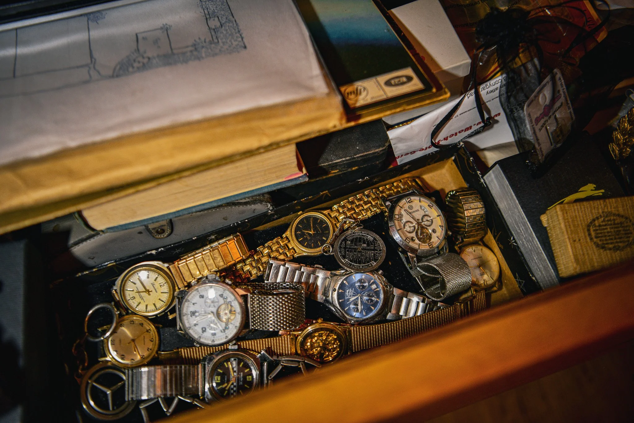 A collection of various wristwatches inside an open wooden box.