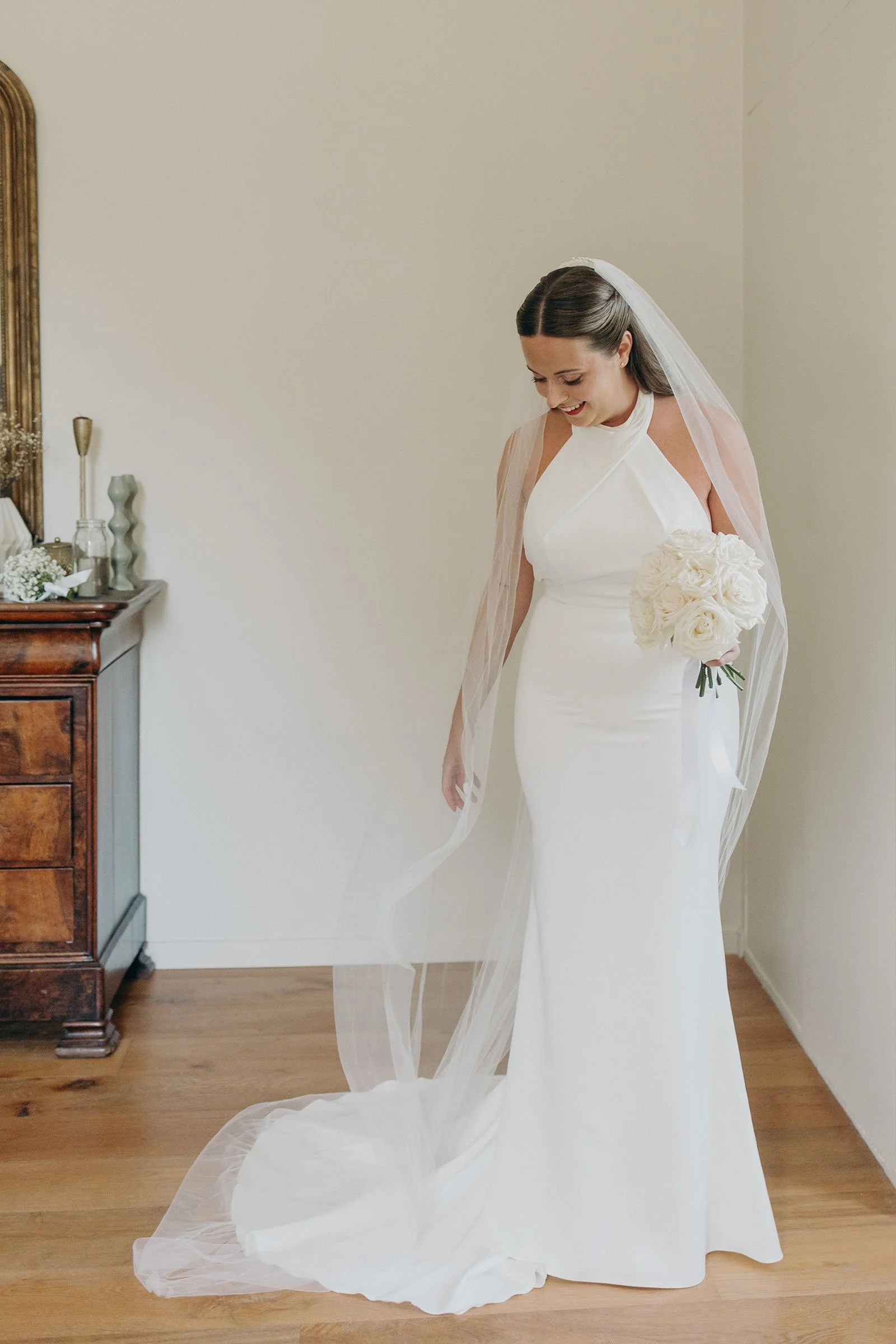 portrait mariée en robe blanche tenant un bouquet de roses blanches au Mas des Costes