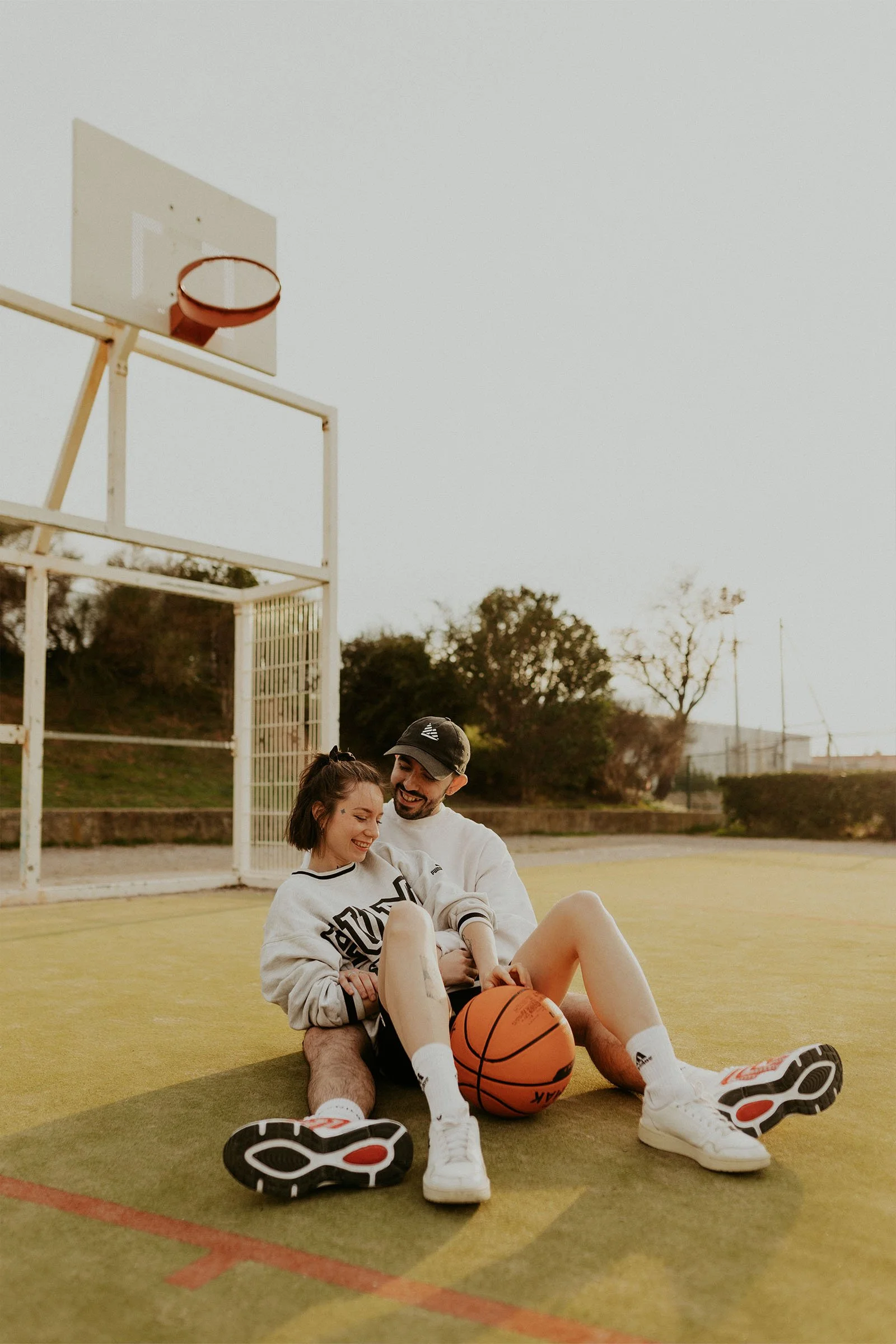 séance photo couple assis sur un terrain de basketball en Provence
