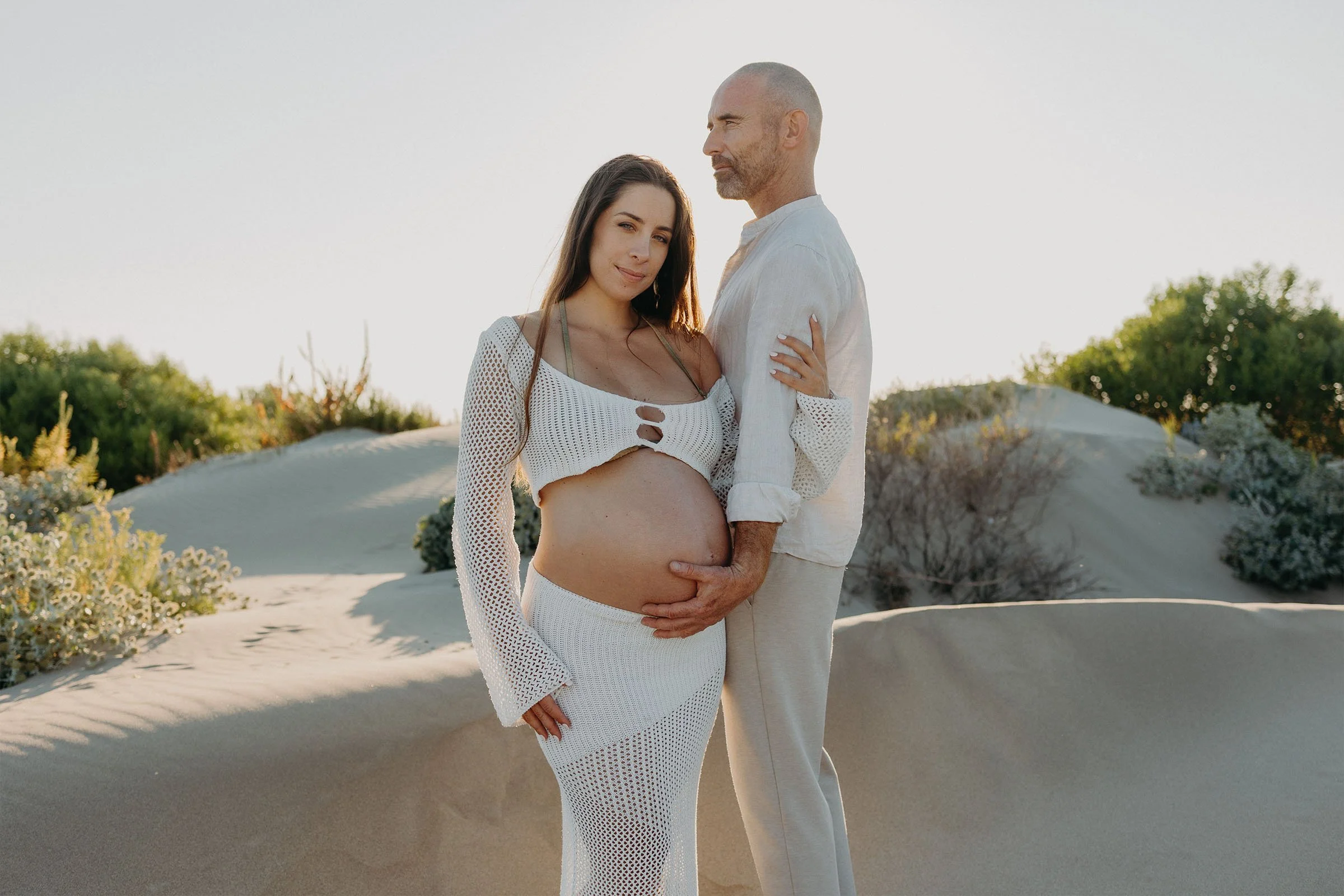 couple attendant un bébé lors d’une séance photo grossesse dans les dunes de Camargue