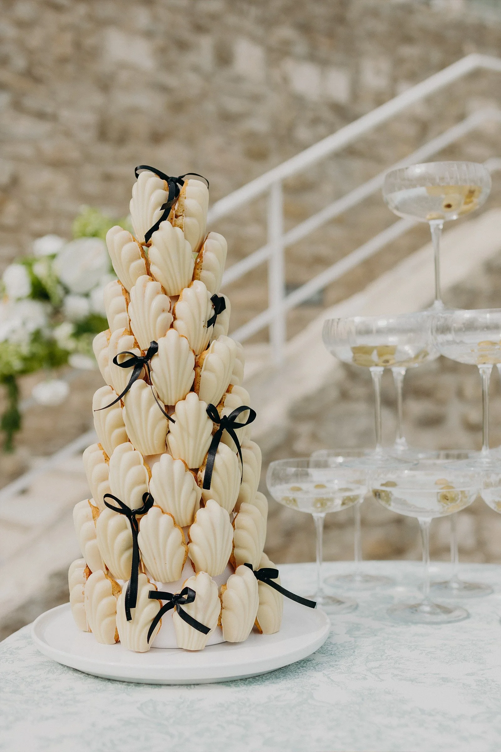 pièce montée de mariage en madeleines entourée de coupes à champagne