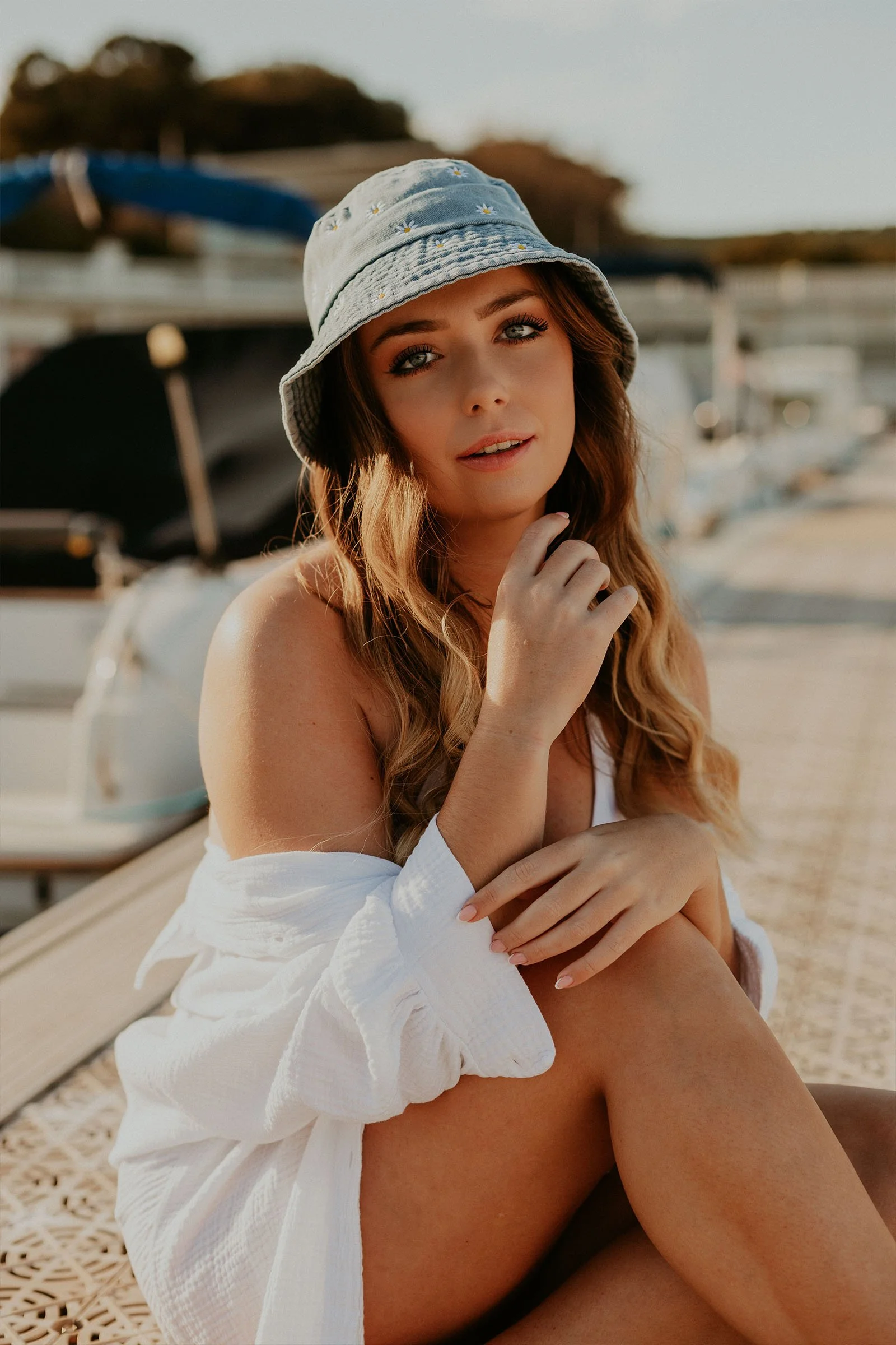 jeune femme assise près d'un bateau lors d'une séance photo portrait sur la Côte Bleue