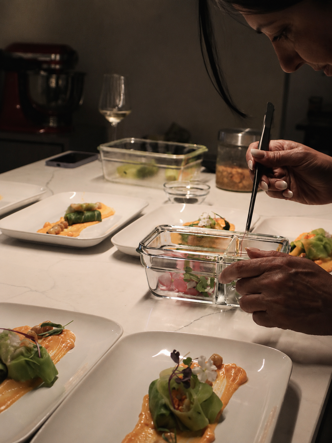 Simin carefully plating a course for guests at her private dining experience in Madeira.