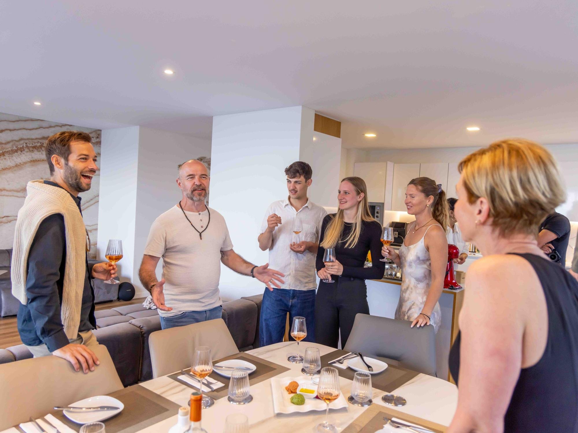 Guests standing around the table, sharing a moment before the dinner begins.
