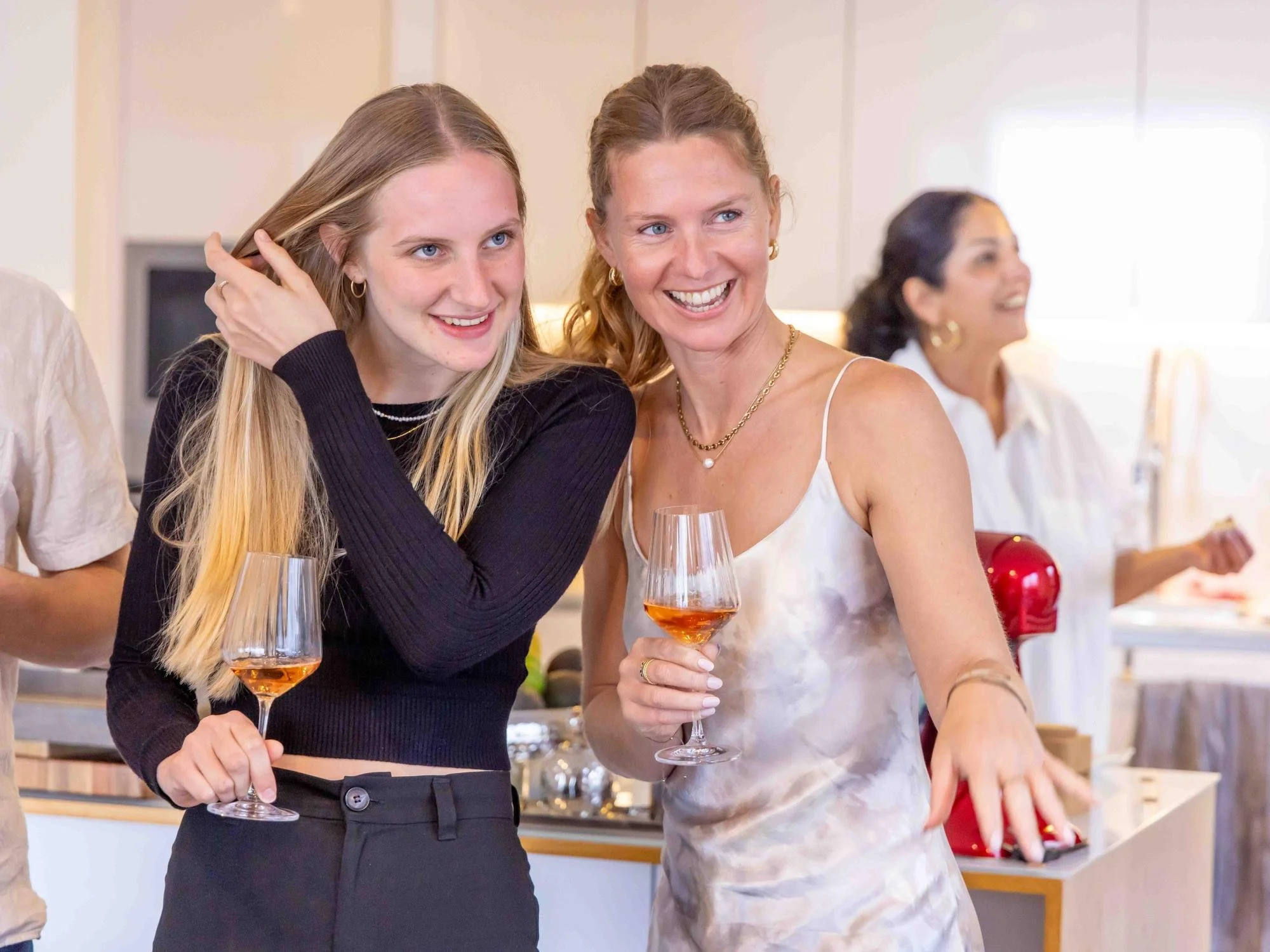 Two women sharing wine at a private dinner.