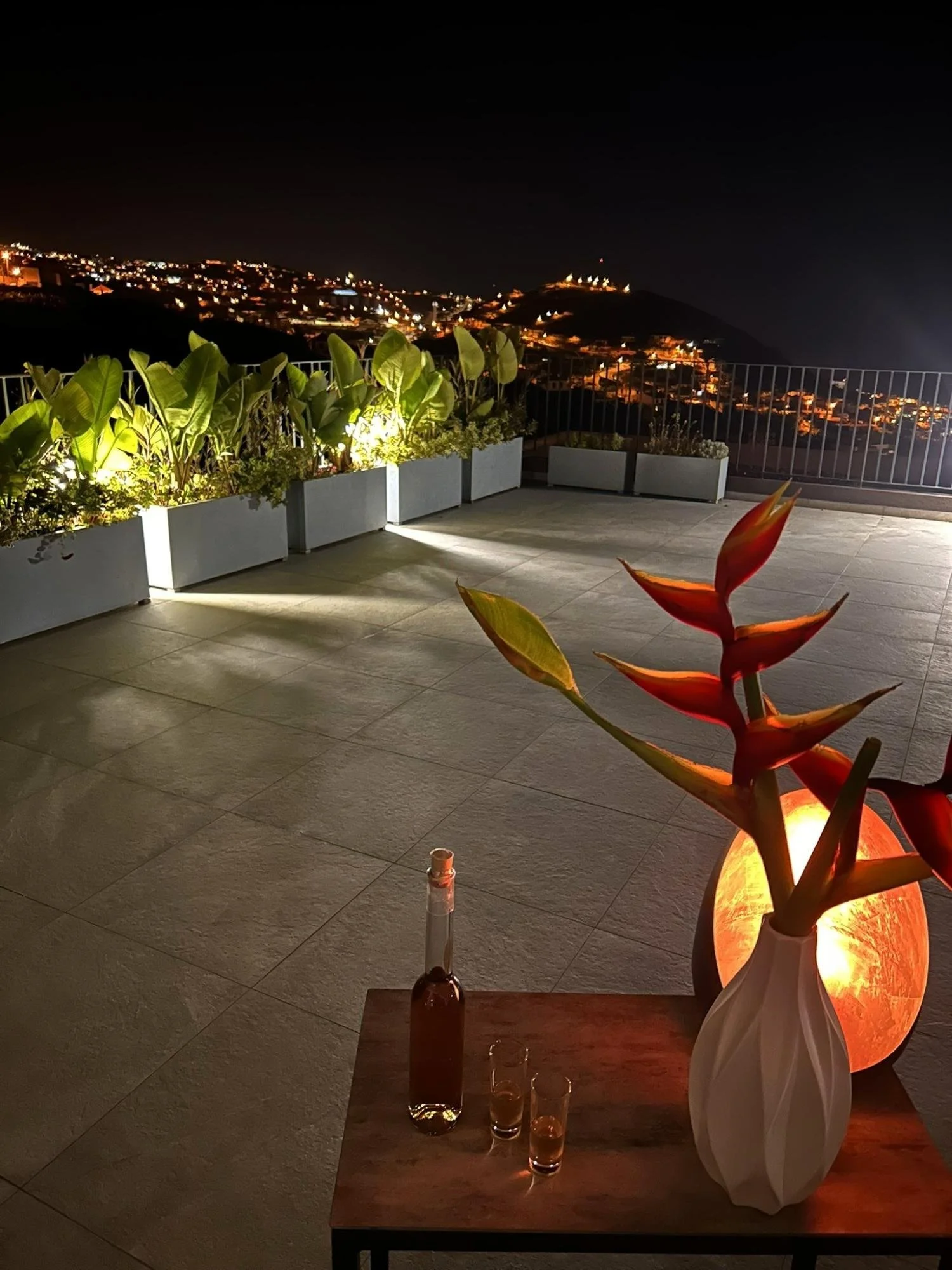 Rooftop terrace at night overlooking city lights in Madeira.