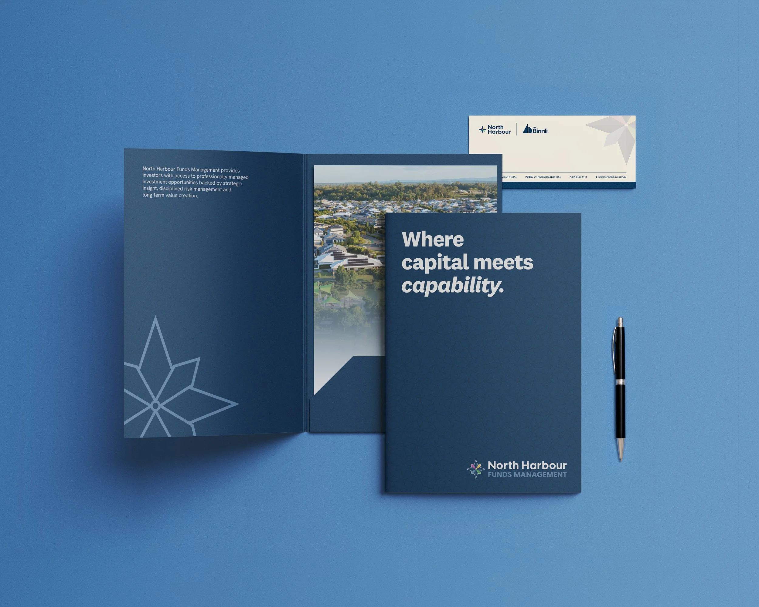 Brochures and notepad on a blue desk with a black pen, branding for North Harbour Funds Management, including a logo and slogan 'Where capital meets capability.'