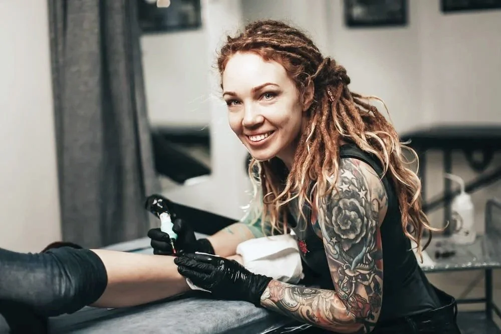 Tattoo artist working on a client in a studio setting.