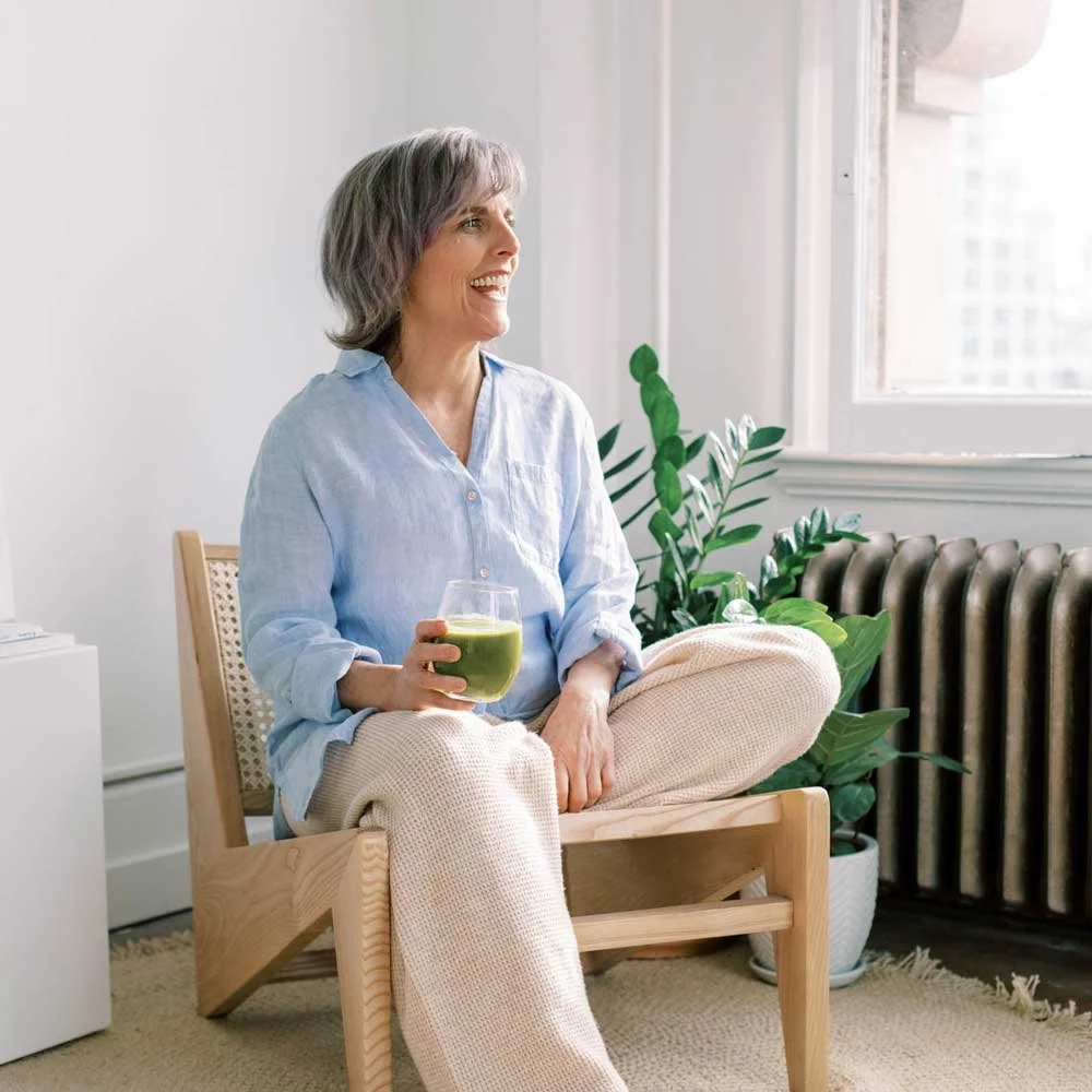 Person seated in a studio with a cup of tea